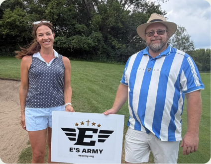 Two supporters holding an E&rsquo;s Army sign at the golf outing